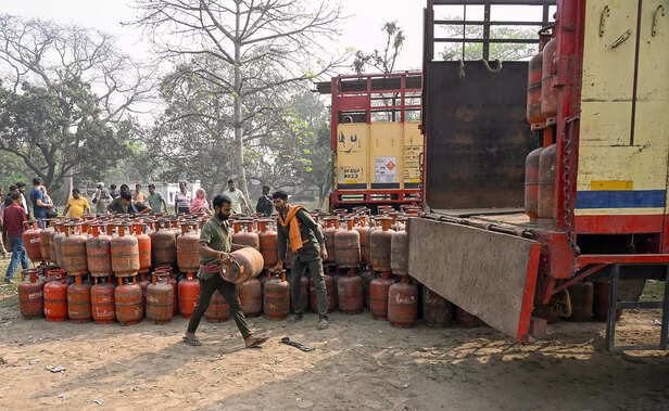 Workers load empty liquefied petroleum gas (LPG) cylinders ...