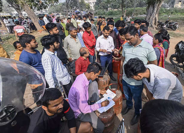 People gather to book domestic LPG cylinders at a gas agenc...