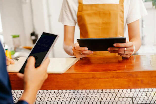 Young Adult Using an iPad in a Coffee Shop