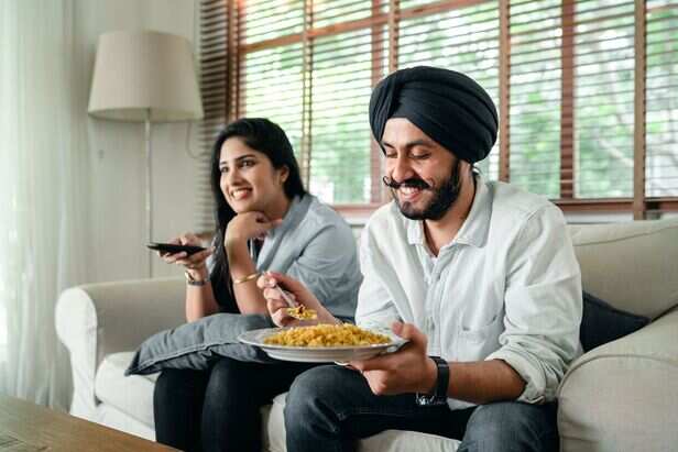 Young Adult Eating Comfort Food While Relaxing at Home