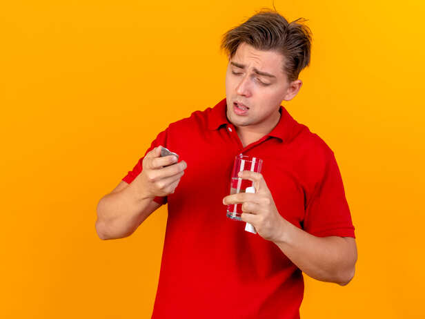 Person holding a glass of beer while experiencing kidney pain