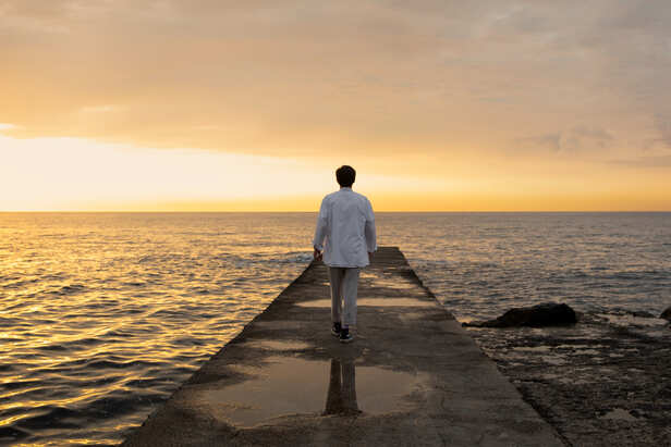Person walking away with confidence at sunrise