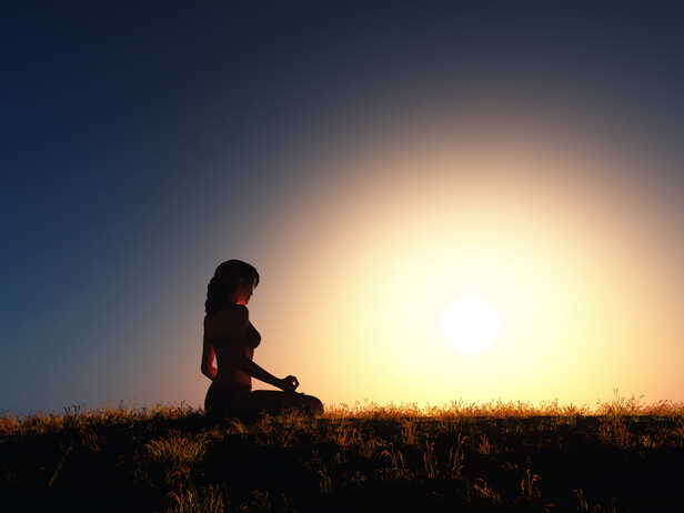 A person offering prayers at sunrise