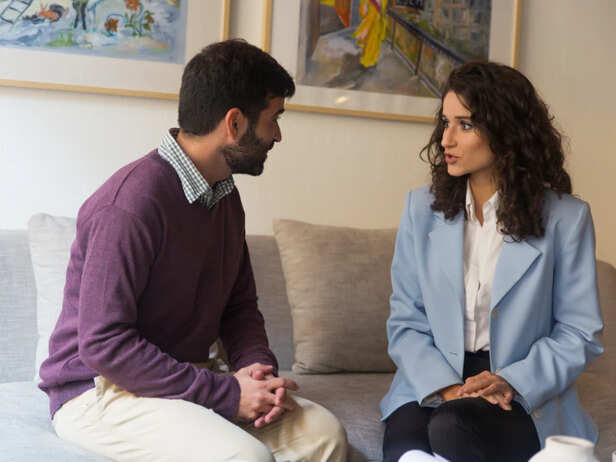 Couple sitting together while one partner feels emotionally distant