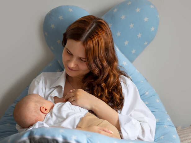 Mother breastfeeding her newborn at home